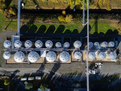 Aerial view of the industrial storage tanks at the Takalaanila facility with metal silos connecting pipes and surrounding greenery in Oulu North Ostrobothnia Finland.