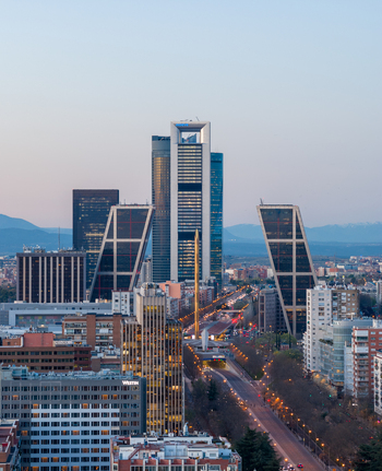 Aerial view of the Cuatro Torres Business Area and KIO Towers in Madrid featuring modern skyscrapers urban roads and distant mountains in Madrid Community of Madrid Spain.