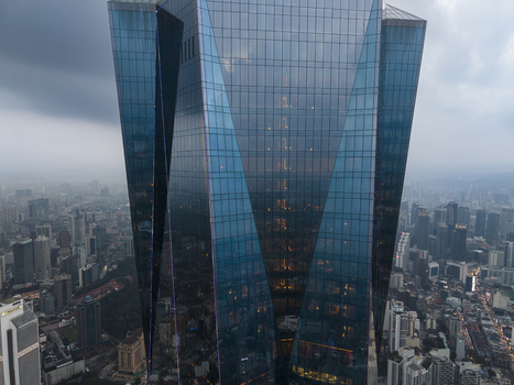 Kuala Lumpur Malaysia 09 March 2026 Aerial view of the Exchange 106 skyscraper with its glass facade reflecting the city skyline under a cloudy sky.
