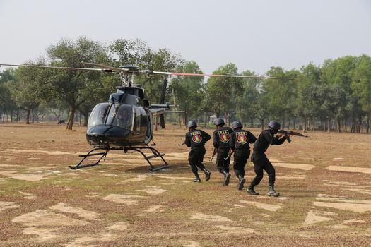 Dhaka Bangladesh 01 February 2017 View of RAB personnel in black uniforms with rifles running near a black helicopter during a drill at the RAB Headquarters. Dhaka Bangladesh 01 February 2017 View of RAB personnel in black uniforms with rifles running near a black helicopter during a drill at the RAB Headquarters.