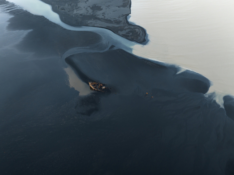 Aerial view of a solitary boat adrift in the dark swirling glacial waters near Skaftafell Iceland. Aerial view of a solitary boat adrift in the dark swirling glacial waters near Skaftafell Iceland.