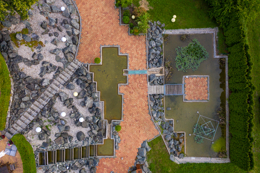 Aerial view of a modern landscaped garden featuring geometric ponds red brick pathways and decorative rock formations Forchheim Bavaria Germany. Aerial view of a modern landscaped garden featuring geometric ponds red brick pathways and decorative rock formations Forchheim Bavaria Germany.