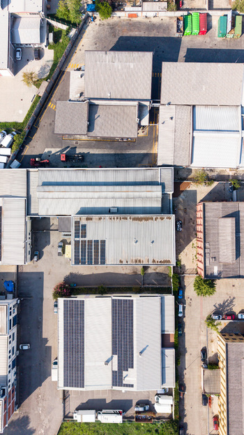 Aerial view of an industrial zone featuring warehouses with solar panel installations parking lots and access roads in Milan Lombardy Italy. Aerial view of an industrial zone featuring warehouses with solar panel installations parking lots and access roads in Milan Lombardy Italy.