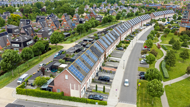 Aerial view of modern residential houses with solar panels on rooftops green trees and suburban streets in Heerhugowaard North Holland Netherlands. Aerial view of modern residential houses with solar panels on rooftops green trees and suburban streets in Heerhugowaard North Holland Netherlands.