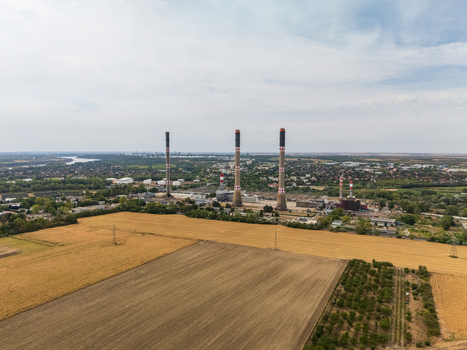 Aerial view of Danube Power Plant in Szazhalombatta Hungary gas fired power station with chimneys transmission lines farmland and urban landscape in Pest County. Aerial view of Danube Power Plant in Szazhalombatta Hungary gas fired power station with chimneys transmission lines farmland and urban landscape in Pest County.