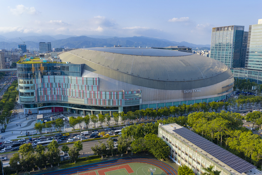 Aerial view of Taipei Dome surrounded by modern urban buildings lush green trees and busy city streets in Taipei Taiwan. Aerial view of Taipei Dome surrounded by modern urban buildings lush green trees and busy city streets in Taipei Taiwan.