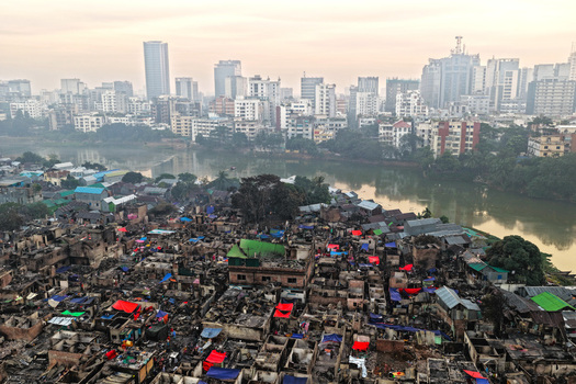 Aerial view of the aftermath of a fire in the Korail Basti slum showing charred structures and debris near the lake with the Dhaka skyline Dhaka Dhaka Division Bangladesh.