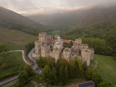 Aerial view of Manasija Monastery a medieval Serbian Orthodox monastery with stone walls and towers surrounded by lush green hills and forests in Despotovac Pomoravski okrug Serbia.