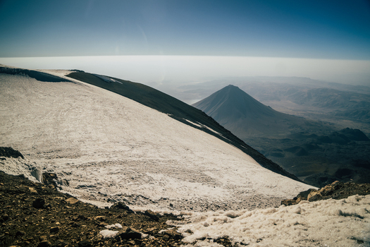 View of Mount Ararat with its snow covered slopes and rocky terrain under a clear blue sky in Turkey.