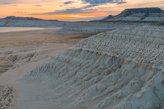Aerial view of the dramatic white limestone cliffs and salt flats of Tuzbair at sunset with textured rock formations in Mangystau District Mangystau Region Kazakhstan.