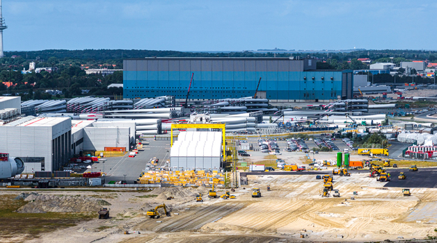 Aerial view of Siemens Gamesa Renewable Energy facility with rows of wind turbine blades industrial buildings and construction machinery in Cuxhaven Niedersachsen Germany.