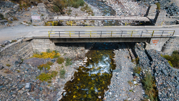 Aerial view of Sadpara Gol bridge crossing a rocky stream with clear water and surrounding mountainous terrain in Skardu Gilgit Pakistan.