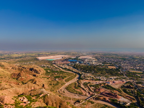 Aerial view of the Khewra Salt Mine area featuring rugged hills industrial infrastructure and surrounding arid landscape in Khewra Punjab Pakistan.