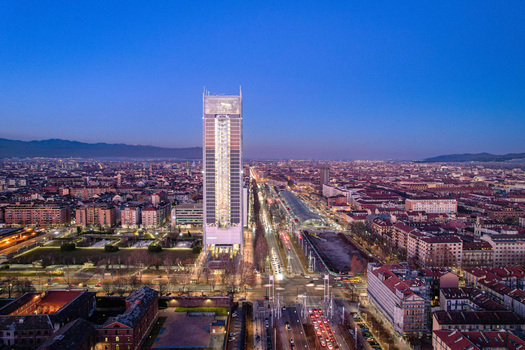 Aerial view of the Intesa Sanpaolo Skyscraper illuminated at dusk with the city skyline and mountains in the background Torino Piemonte Italy. Aerial view of the Intesa Sanpaolo Skyscraper illuminated at dusk with the city skyline and mountains in the background Torino Piemonte Italy.