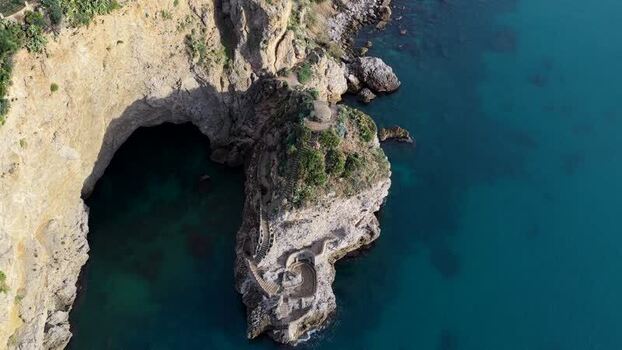Aerial view of coastal cliffs and sea cave in Terrasini Italy.
