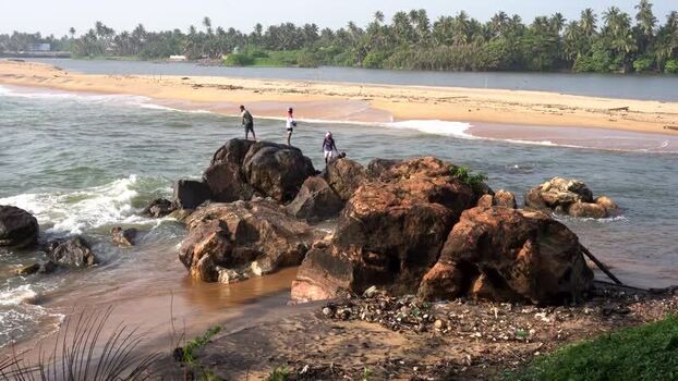 View of people standing on rocks by the crashing waves Sri Lanka View of people standing on rocks by the crashing waves Sri Lanka