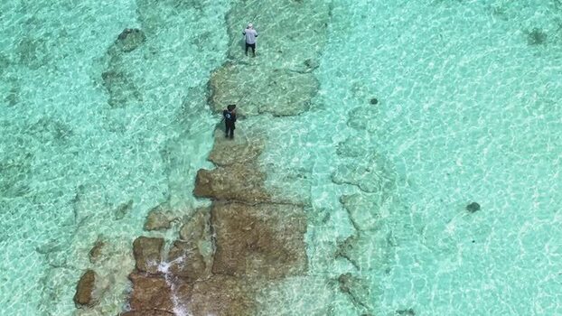 Aerial view of fishermen on a rocky reef Maldives.