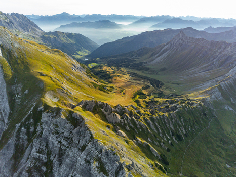 Aerial view of Lunersee surrounded by dramatic alpine peaks lush green mountain slopes and rocky ridges under soft morning light in Vandans Vorarlberg Austria. Aerial view of Lunersee surrounded by dramatic alpine peaks lush green mountain slopes and rocky ridges under soft morning light in Vandans Vorarlberg Austria.