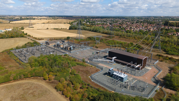 Aerial view of the Eaton Socon Substation and Battery Energy Storage System with electrical infrastructure and power lines set within a rural landscape in St. Neots England United Kingdom. Aerial view of the Eaton Socon Substation and Battery Energy Storage System with electrical infrastructure and power lines set within a rural landscape in St. Neots England United Kingdom.