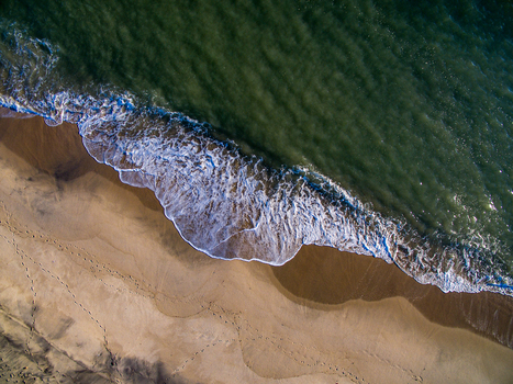 Aerial view of Katama Beach with gentle waves washing over the sandy shoreline and footprints visible on the beach Edgartown Massachusetts United States. Aerial view of Katama Beach with gentle waves washing over the sandy shoreline and footprints visible on the beach Edgartown Massachusetts United States.