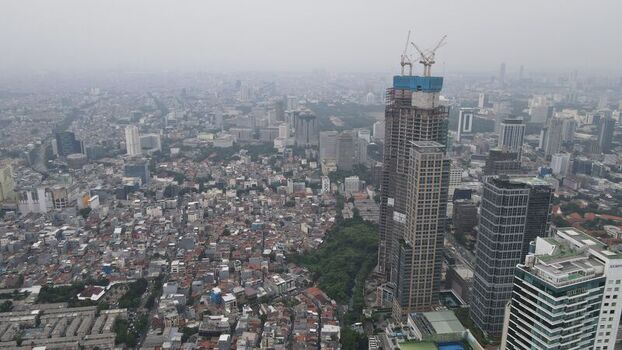 Aerial view of Jakarta Pusat with high rise buildings under construction dense residential rooftops and urban infrastructure in Kecamatan Menteng Daerah Khusus Ibukota Indonesia. Aerial view of Jakarta Pusat with high rise buildings under construction dense residential rooftops and urban infrastructure in Kecamatan Menteng Daerah Khusus Ibukota Indonesia.