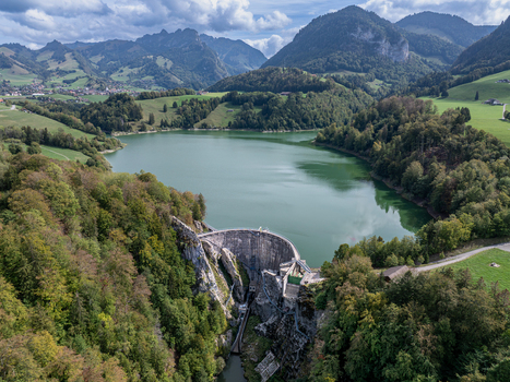 Aerial view of Barrage de Montsalvens dam surrounded by lush green forests and mountains with the reservoir lake in Chatel sur Montsalvens Fribourg Switzerland. Aerial view of Barrage de Montsalvens dam surrounded by lush green forests and mountains with the reservoir lake in Chatel sur Montsalvens Fribourg Switzerland.