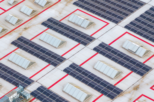 Aerial view of solar panels and skylights on an industrial roof with red geometric markings in Breclav South Moravian Region Czechia.