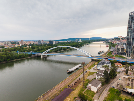 Aerial view of Apollo Bridge spanning the Danube River with the city skyline and Bratislava Castle under a cloudy sky Bratislava Bratislava Region Slovakia. Aerial view of Apollo Bridge spanning the Danube River with the city skyline and Bratislava Castle under a cloudy sky Bratislava Bratislava Region Slovakia.