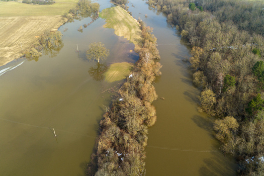 Aerial view of flooded fields and overflowing river banks with bare trees and submerged meadows in Kaniukai Kaunas County Lithuania. Aerial view of flooded fields and overflowing river banks with bare trees and submerged meadows in Kaniukai Kaunas County Lithuania.