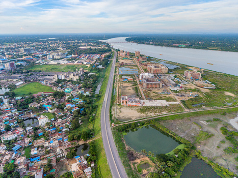 Aerial view of Kalurghat New River view Road stretching along the Karnaphuli River with urban development industrial buildings and green fields Chattogram Chittagong Division Bangladesh.