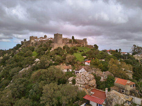 Aerial view of the ancient Castellar Viejo fortress perched atop a verdant hill under a brooding sky Castellar de la Frontera Andalucía Spain. Aerial view of the ancient Castellar Viejo fortress perched atop a verdant hill under a brooding sky Castellar de la Frontera Andalucía Spain.