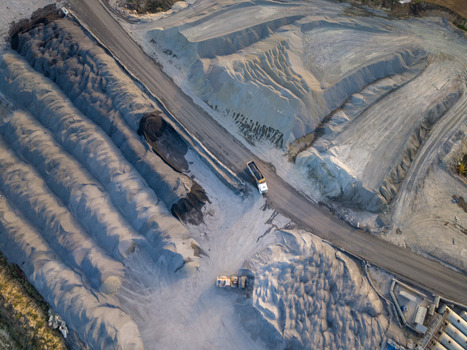 Aerial view of a large industrial quarry with massive piles of gravel and sand heavy machinery and a dump truck driving along a dirt road in Istanbul Istanbul Turkiye.