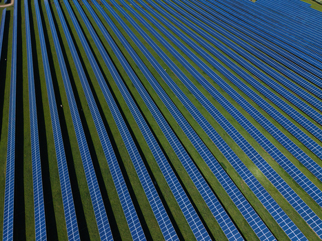Aerial view of solar panels arranged in neat diagonal rows across a green field at Chelveston Renewable Energy Park in Wellingborough England United Kingdom. Aerial view of solar panels arranged in neat diagonal rows across a green field at Chelveston Renewable Energy Park in Wellingborough England United Kingdom.