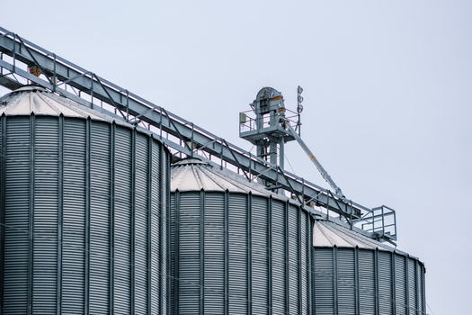 View of towering metallic grain silos gleaming under a muted sky interconnected by conveyor structures in Sremska Mitrovica Vojvodina Serbia. View of towering metallic grain silos gleaming under a muted sky interconnected by conveyor structures in Sremska Mitrovica Vojvodina Serbia.