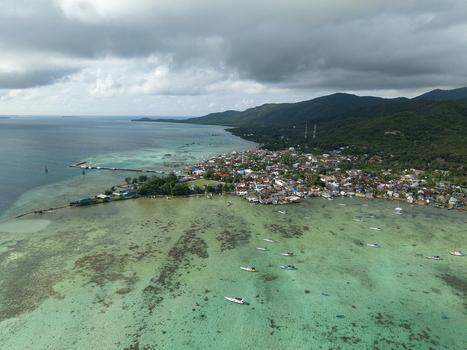 Aerial view of the vibrant Karimunjawa Town Square nestled between the turquoise sea and verdant hills Karimunjawa Central Java Indonesia. Aerial view of the vibrant Karimunjawa Town Square nestled between the turquoise sea and verdant hills Karimunjawa Central Java Indonesia.
