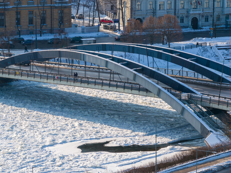 Aerial view of the Mindaugas Bridge spanning across the frozen Neris River filled with ice floes in winter Vilnius County Lithuania.