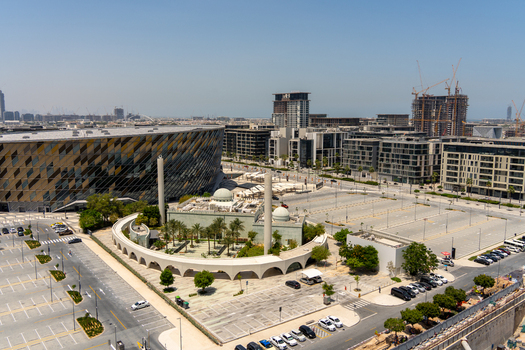 Aerial view of the Coca Cola Arena featuring its modern geometric facade and circular structure surrounded by urban development and construction sites in Dubai Dubai United Arab Emirates. Aerial view of the Coca Cola Arena featuring its modern geometric facade and circular structure surrounded by urban development and construction sites in Dubai Dubai United Arab Emirates.