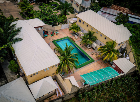 Aerial view of the Barnawa residential complex featuring a swimming pool palm trees and light colored buildings in Kaduna Kaduna Nigeria. Aerial view of the Barnawa residential complex featuring a swimming pool palm trees and light colored buildings in Kaduna Kaduna Nigeria.