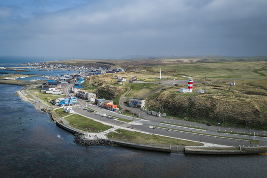 Aerial view of Cape Soya with its iconic red and white lighthouse coastal road and surrounding grassy hills overlooking the sea in Wakkanai Hokkaido Japan. Aerial view of Cape Soya with its iconic red and white lighthouse coastal road and surrounding grassy hills overlooking the sea in Wakkanai Hokkaido Japan.
