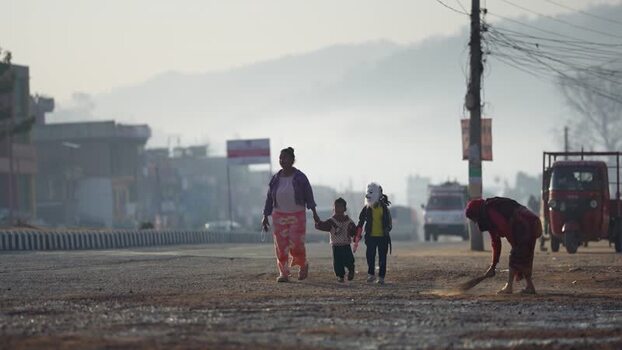 View of a woman walking with children on a street in Dhangadhi Nepal. View of a woman walking with children on a street in Dhangadhi Nepal.