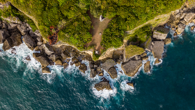 Aerial view of Cabo Frances Viejo with rugged cliffs lush green vegetation and crashing waves along the coastline in Cabrera Maria Trinidad Sanchez Dominican Republic.