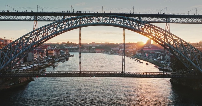 Aerial view of the Dom Luis I Bridge spanning the Douro River at sunset with the historic city skyline of Porto in the background Porto Portugal. Aerial view of the Dom Luis I Bridge spanning the Douro River at sunset with the historic city skyline of Porto in the background Porto Portugal.