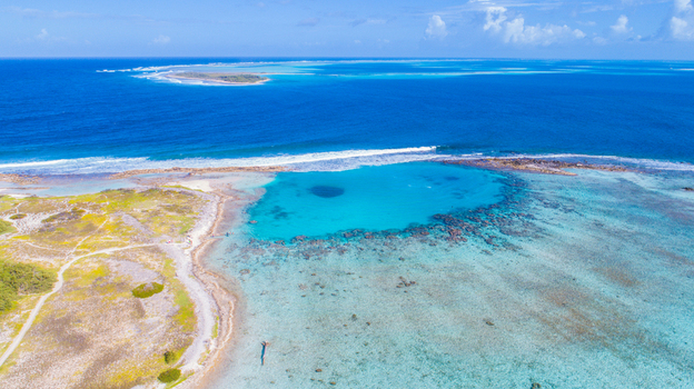 Aerial view of the Los Roques archipelago featuring turquoise waters coral reefs and sandy coastlines under a clear blue sky in Los Roques Dependencias Federales Venezuela. Aerial view of the Los Roques archipelago featuring turquoise waters coral reefs and sandy coastlines under a clear blue sky in Los Roques Dependencias Federales Venezuela.