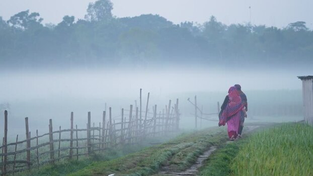 View of people walking on a misty path in Bogura Bangladesh.