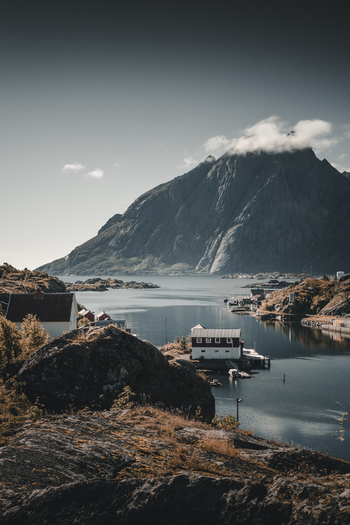 Sund Norway 08 September 2022 View of the coastal village of Sund nestled among rocky terrain and calm waters with traditional red houses in Nordland Norway.