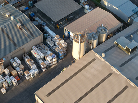 Kilsyth VIC Australia 22 September 2026 Aerial view of industrial factories featuring large metal silos storage tanks and rows of stacked containers in a paved yard. Kilsyth VIC Australia 22 September 2026 Aerial view of industrial factories featuring large metal silos storage tanks and rows of stacked containers in a paved yard.