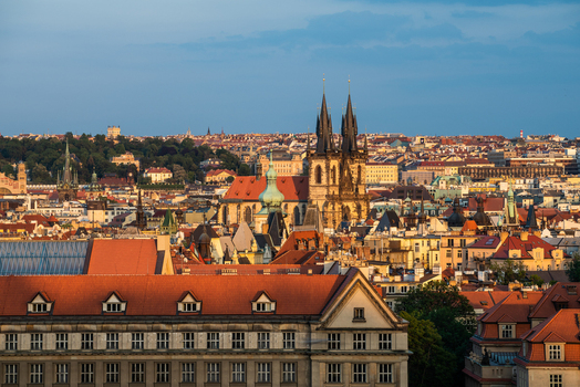 View of the Church of Our Lady before Tyn rising above the historic rooftops of the city skyline during golden hour in Prague Prague Czechia.