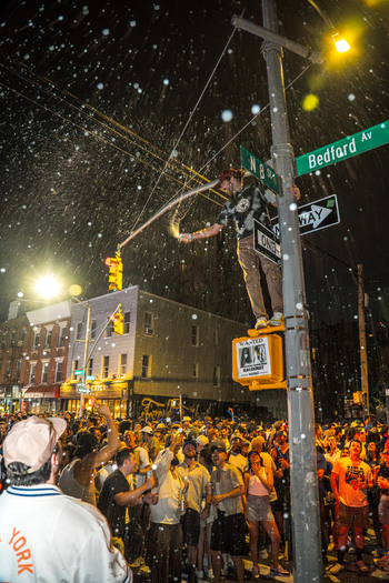 Williamsburg Brooklyn New York USA 14 June 2026 View of fans celebrating the Knicks NBA championship victory on a street corner at night with champagne. Williamsburg Brooklyn New York USA 14 June 2026 View of fans celebrating the Knicks NBA championship victory on a street corner at night with champagne.