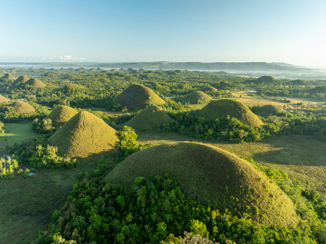 Aerial view of the Chocolate Hills a geological formation of numerous grass covered limestone mounds in Batuan Central Visayas Philippines. Aerial view of the Chocolate Hills a geological formation of numerous grass covered limestone mounds in Batuan Central Visayas Philippines.
