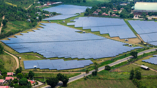 Bais City Philippines 20 September 2026 Aerial view of a large solar farm with rows of photovoltaic panels set in a rural landscape with surrounding greenery and roads.